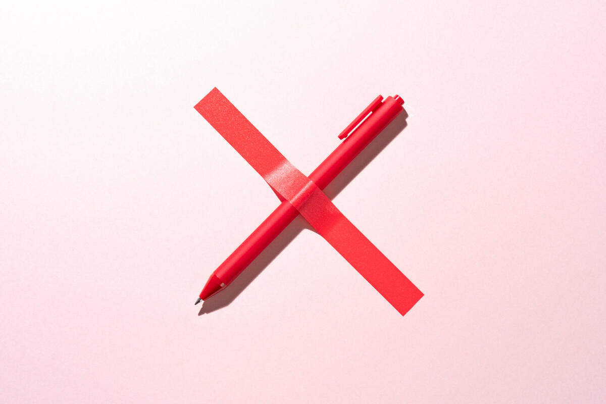 Rotes Kreuz bestehend aus einem Stift und einem Streifen Klebeband © MirageC / Getty Images 