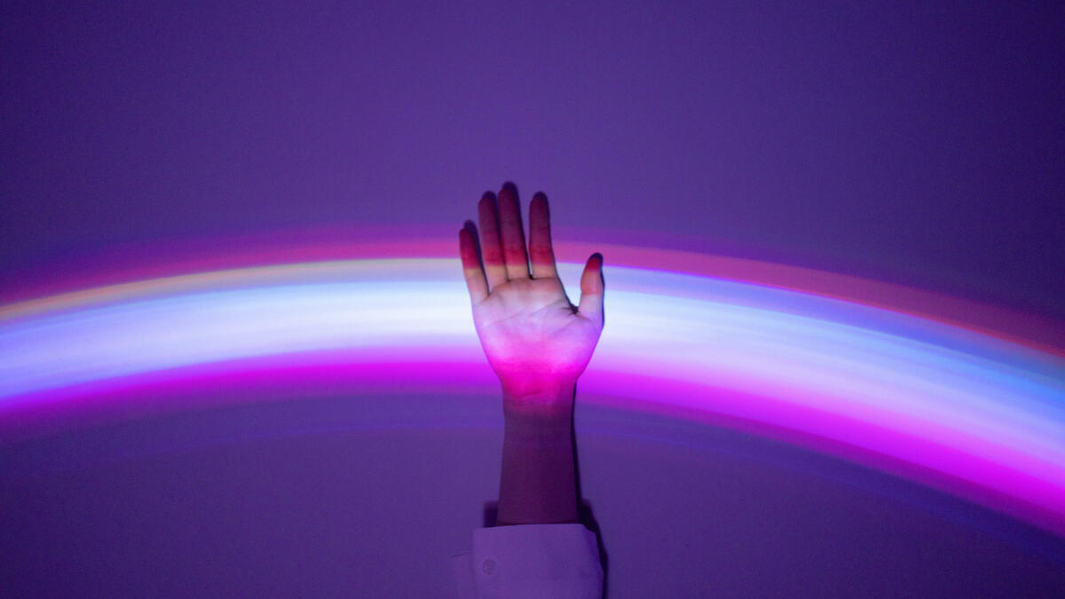 Hand, die sich meldet und in einem lila Lichtspiel aufleuchtet © Qi Yang / Getty Images
